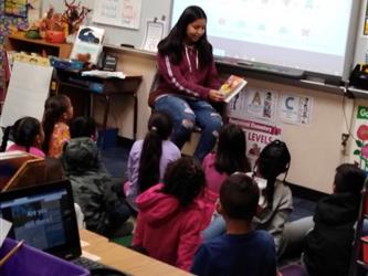 A Student Alliance student  reads to a very interested class.