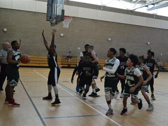 Vista Nueva boys playing in basketball game.